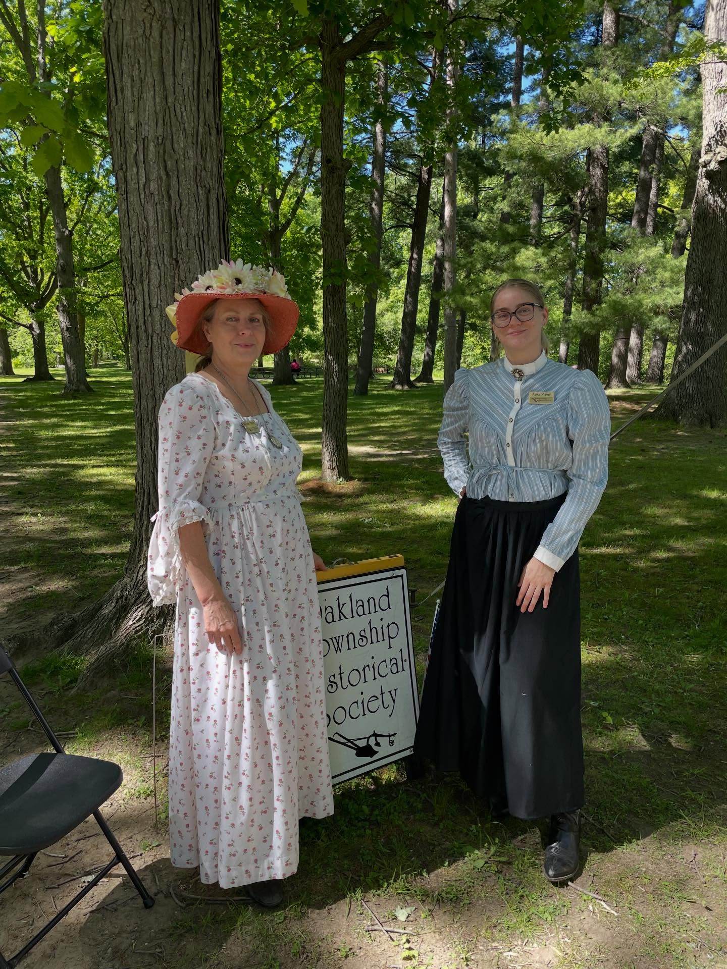 Two Oakland Township Historical Society volunteers in historical dress outdoors